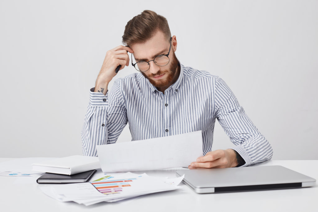 un homme en train de réfléchir devant des documents