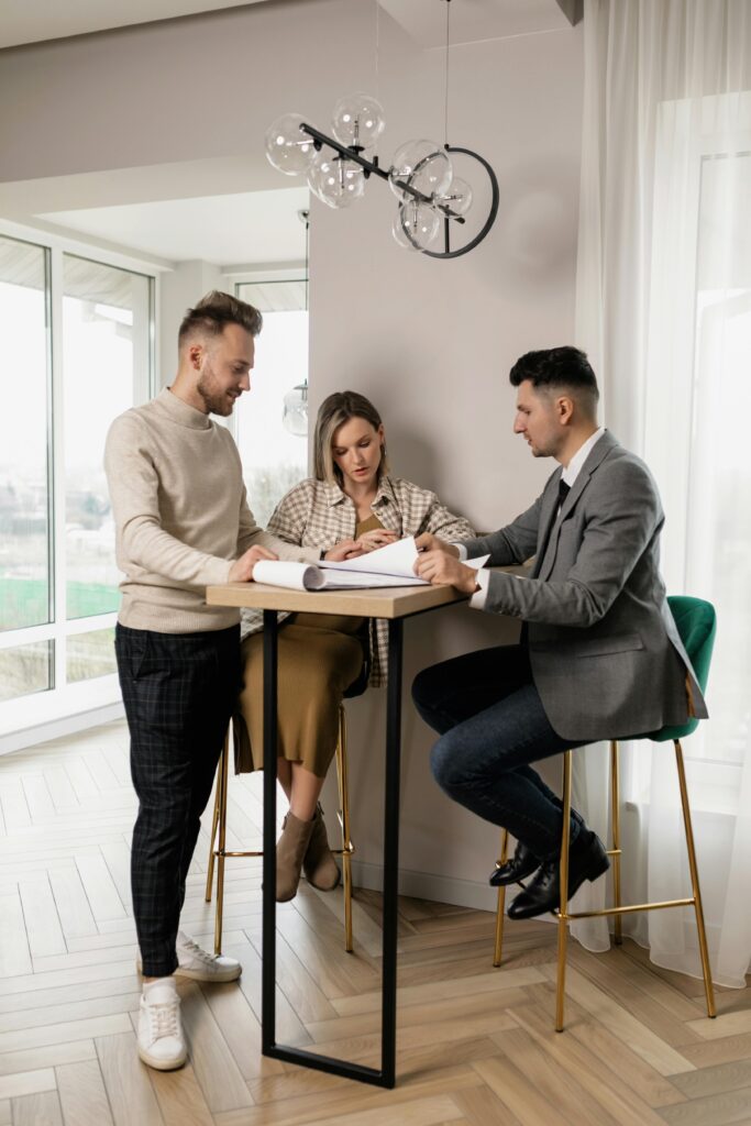 Consultation immobilière entre un couple et un professionnel de l’immobilier.