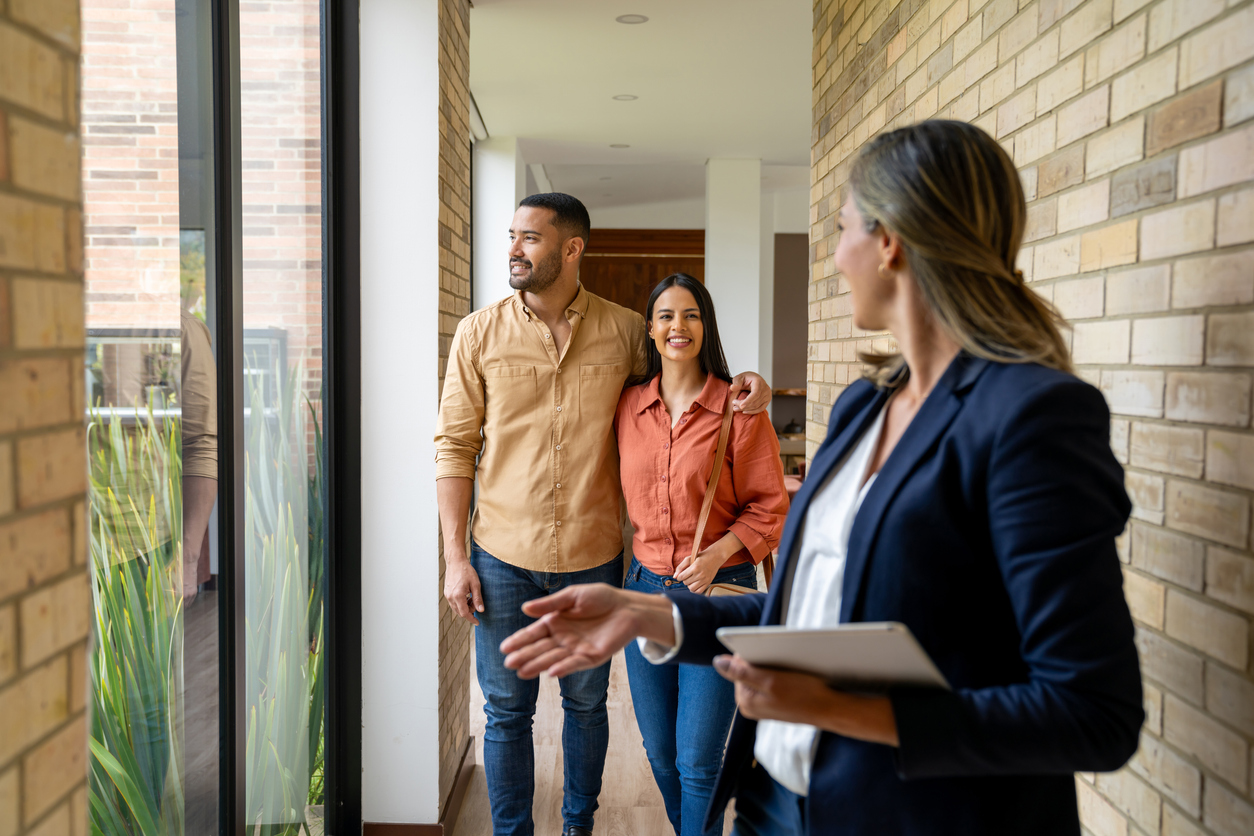 real estate agent showing a house for sale to a couple