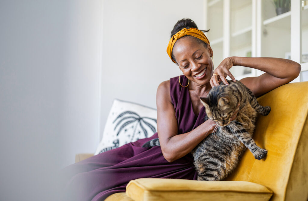 Portrait d’une femme souriante avec son chat à la maison.