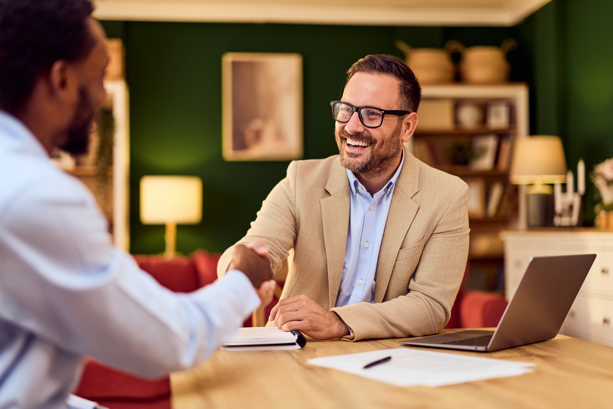 business meeting with handshake between client and advisor in cozy office setting
